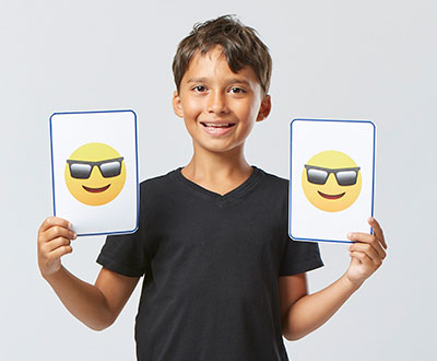 boy holding cards with emojis 