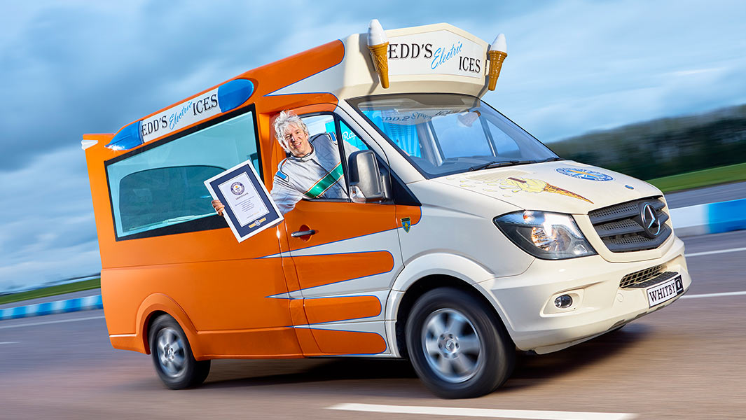 Guinness World Records title holder for electric ice cream van driving along at speed with creator Edd China leaning out of window with certificate