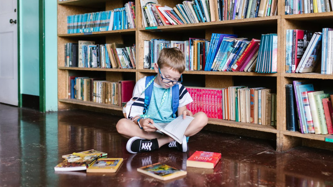 thumbnail kid reading book in library