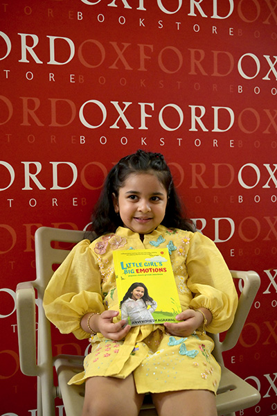 Anvi sat on a chair holding her debut book