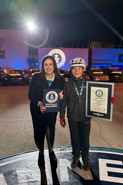 Jordi Sala holding his GWR certificate next to GWR adjudicator Chloe McCarthy