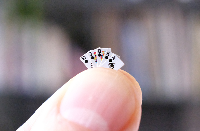 tiny playing cards on finger