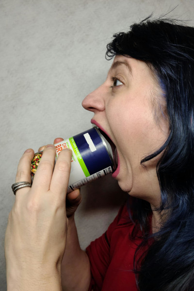 Woman puts can inside mouth