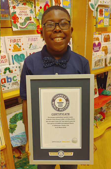 Caleb holding certificate smiling