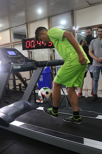 Meraj on a treadmill juggling a football with his feet