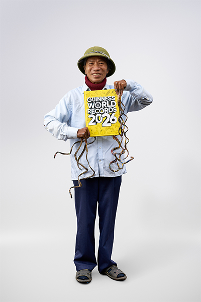 man with longest fingernails holding GWR book