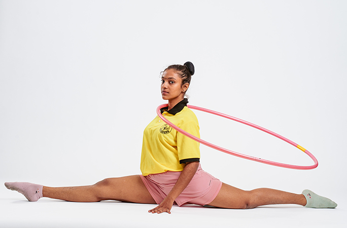 Janani hula hooping with her neck while in the cross splits position