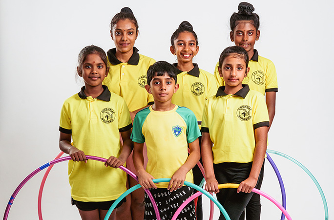 Six of the Chennai Hoopers stood together holding their coloured hoops