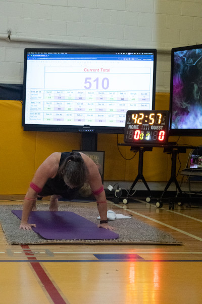 teacher doing push ups screens behind her