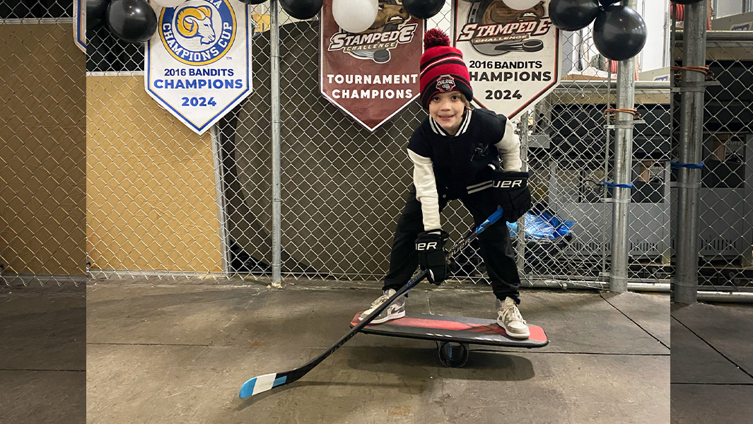 boy playing hockey on balance board