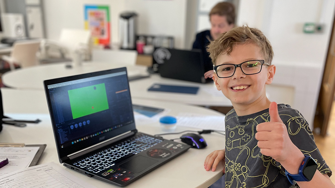 Split image of Max working at his laptop and holding his GWR certificate