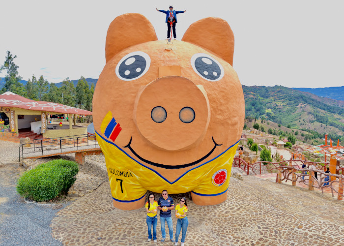 largest piggy bank with people sitting in front