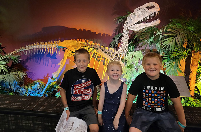 kids posing with dinosaurs