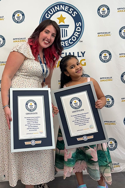 Anvi and Caitlin holding Anvi's two certificates