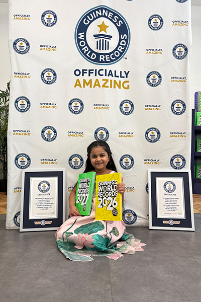 Anvi sat holding two GWR books with her certificates by her side