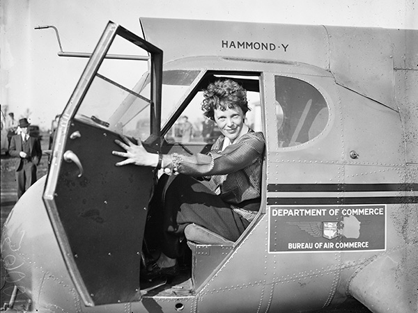 Amelia holding open plane door