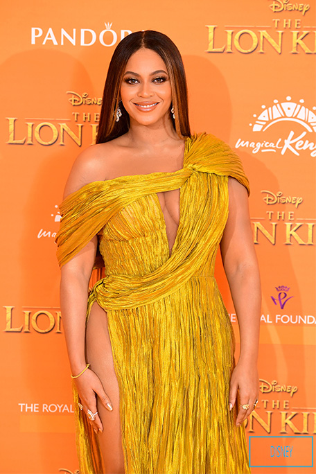 Beyonce smiling while wearing a gold dress
