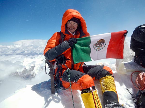 Viridiana holding mexican flag on mountain
