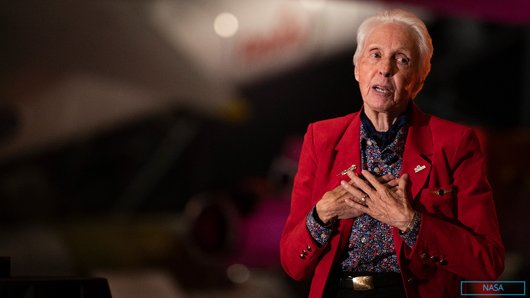wally talking while wearing red blazer