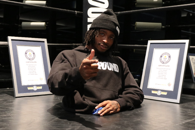 Zion pointing at the camera with his certificates in the background