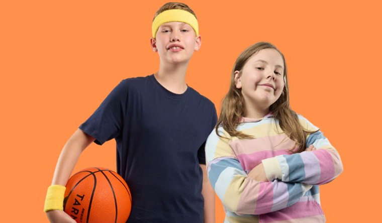 Boy holding a basketball next to a girl with arms folded