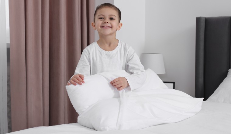 Boy putting a pillow case on a pillow
