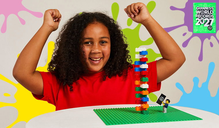 Girl cheering with LEGO tower