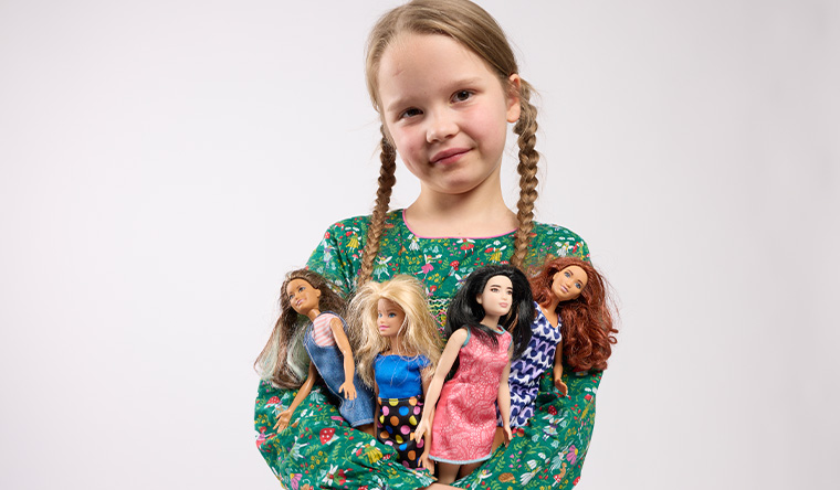 girls dressing up barbie dolls