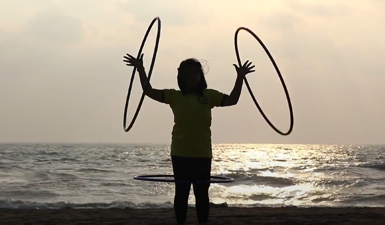 Girl with hula hoops on both arms
