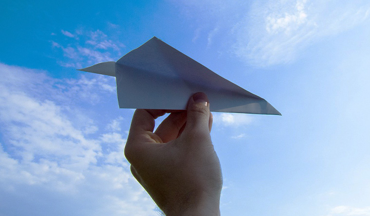 hand holding paper plane