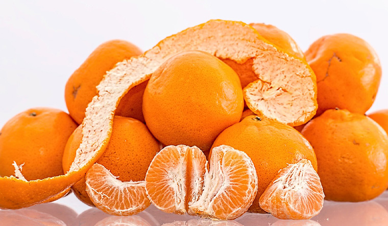 Mandarins whole and one peeled withthe peel on display