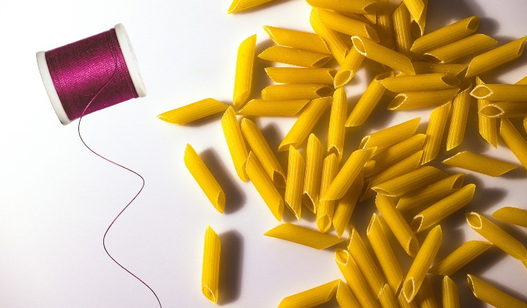 Penne pasta and a reel of cotton
