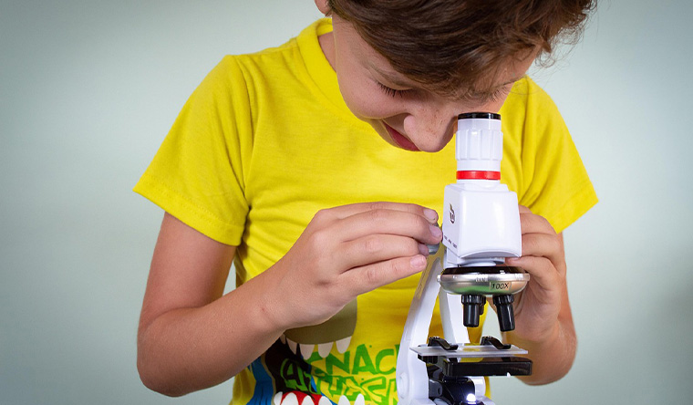 Kid looking at microscope