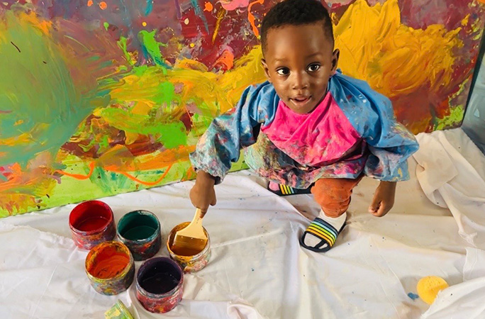 Ace Liam dipping a paintbrush in a paint pot