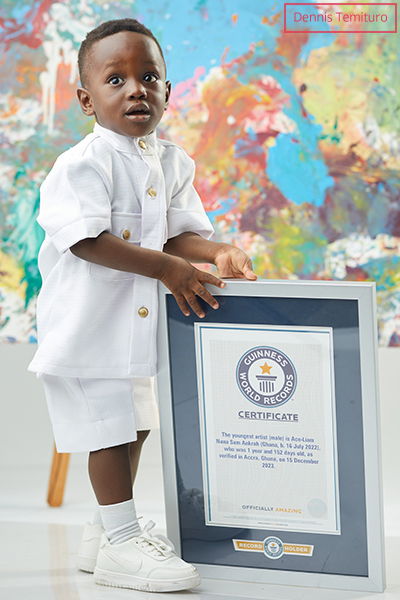 Ace Liam stood with his framed GWR certificate in front of one of his paintings
