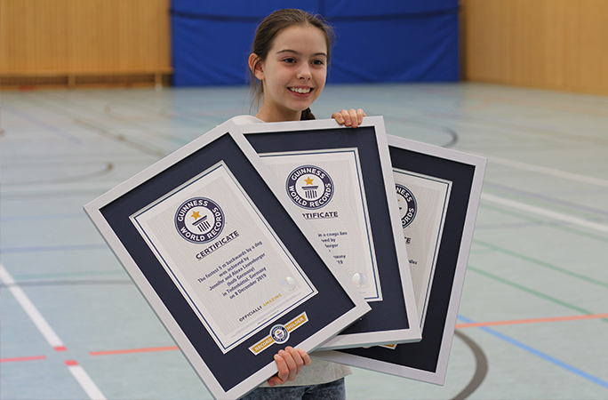 Alexa smiling while holding 3 gwr certificates