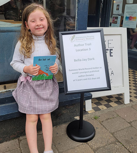 Bella smiling while presenting her book