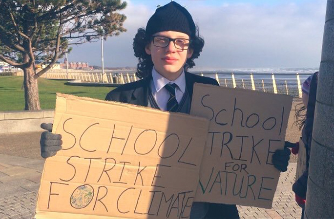 dara holding signs at a school climate strike