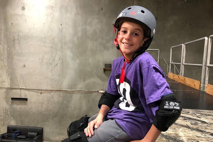 gui wearing helmet and smiling at camera