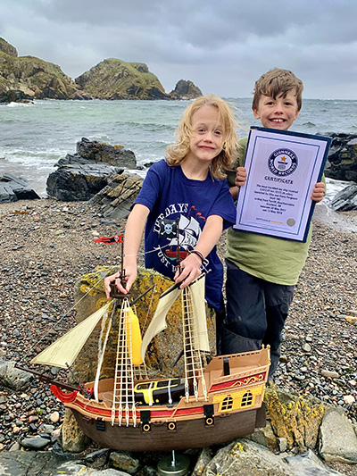 Brothers with boat and certificate