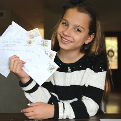 Roxanne Downs holding multiple postcards
