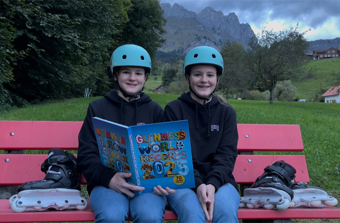 Twins on bench holding book