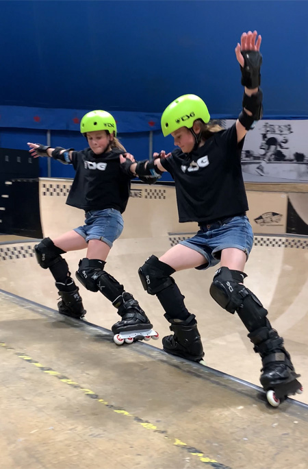 Twins skating holding each other