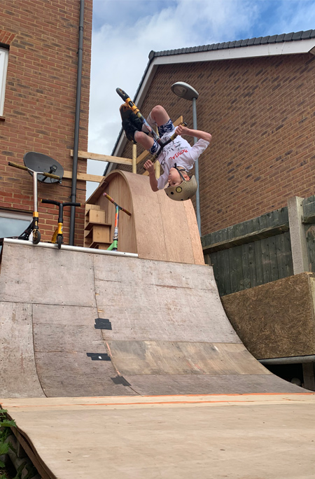 tyler doing a flip on ramp in garden