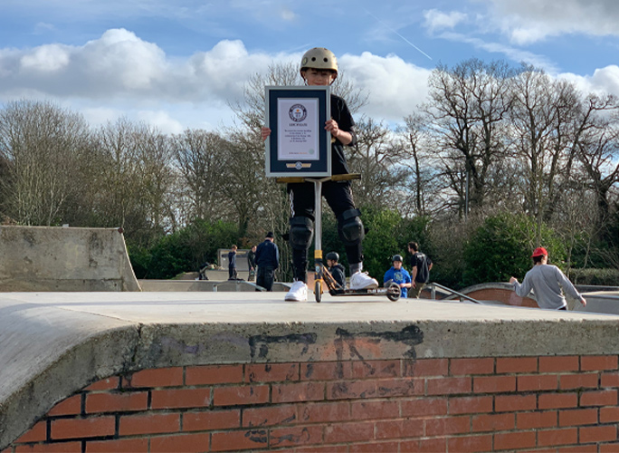 tyler on scooter while holding gwr certificate