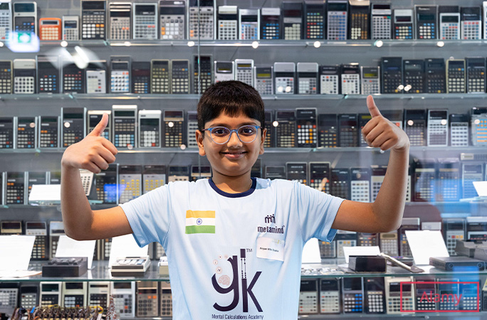 Aaryan giving thumbs up in front of calculators