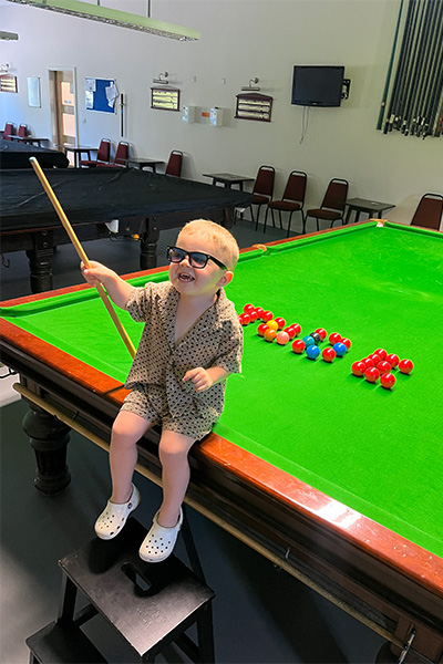 Jude sitting on snooker table