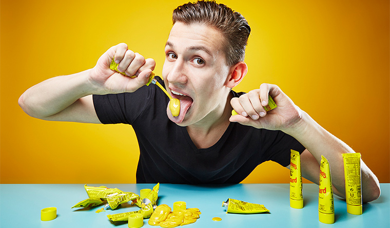man eating mustard