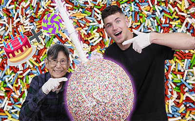 2 men next to giant cake pop