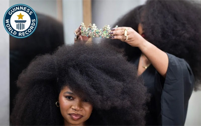 previous largest afro woman putting crown on new holder